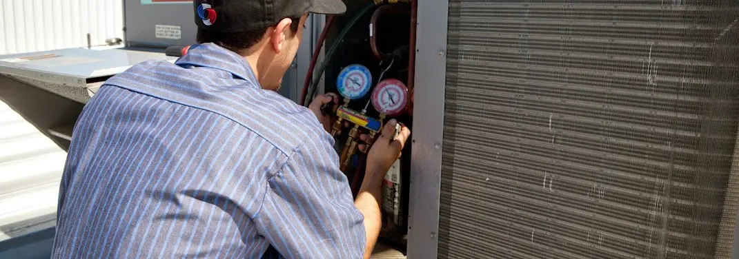 HVAC technician servicing a condenser unit in Cold Springs